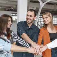 Geschäftsleute im Büro halten Hände zusammen