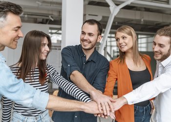 Geschäftsleute im Büro halten Hände zusammen